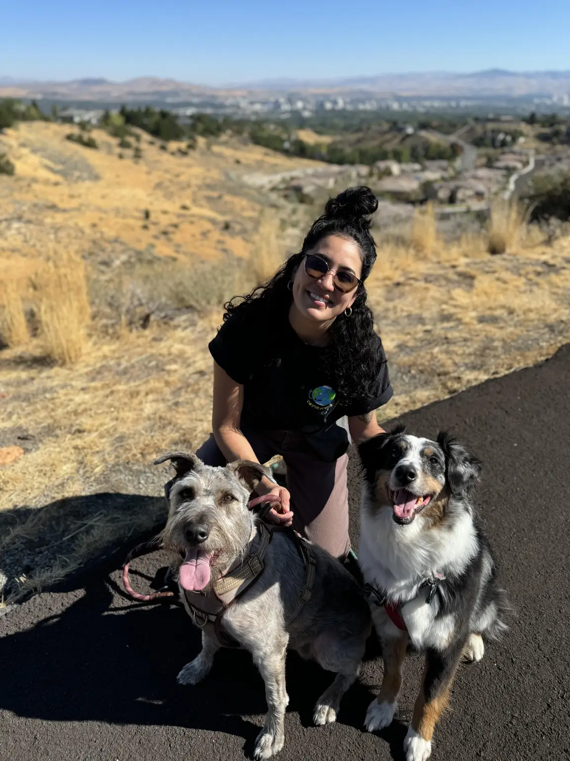 Raquel outside with two happy dogs